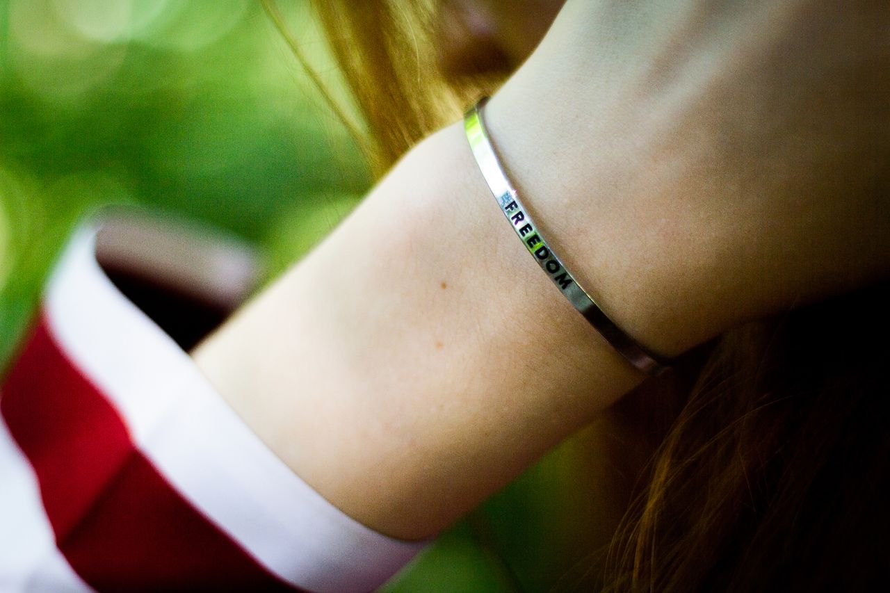 Crafting Captivating Headlines: Your awesome post title goes here A close-up view of a silver bracelet engraved with 'freedom' on a woman's wrist.